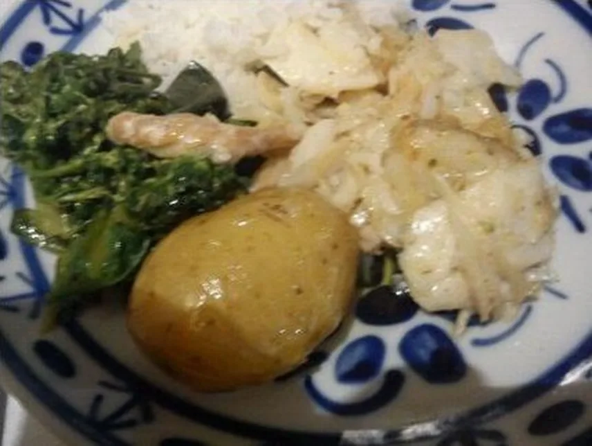 Bacalhau em lascas com batata e couve em prato de louça azul